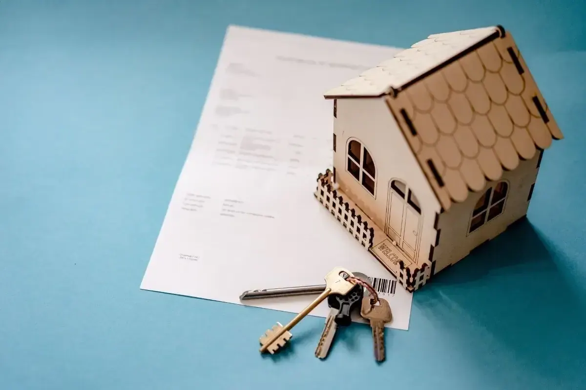 Documents, maquette de maison en bois et clés : les papiers d'une copropriété à vérifier