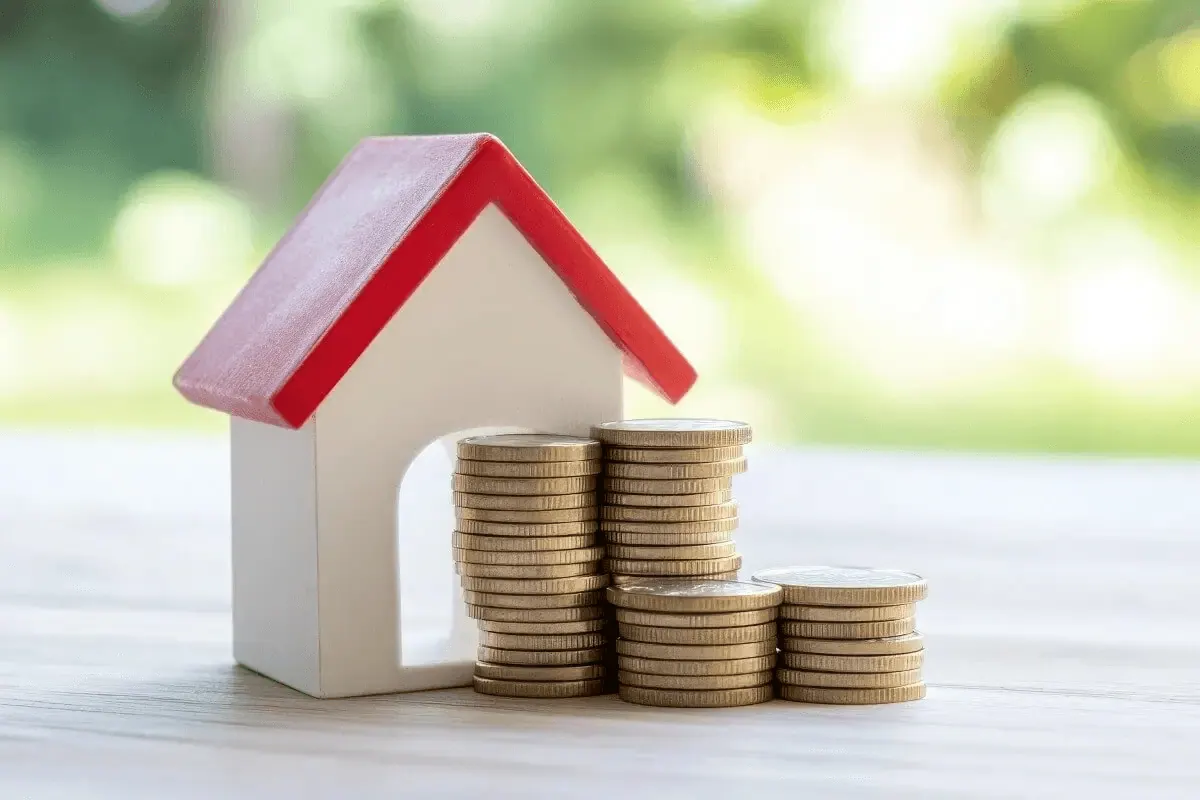 Maquette de maison et pièces empilées, pour illustrer un investissement locatif