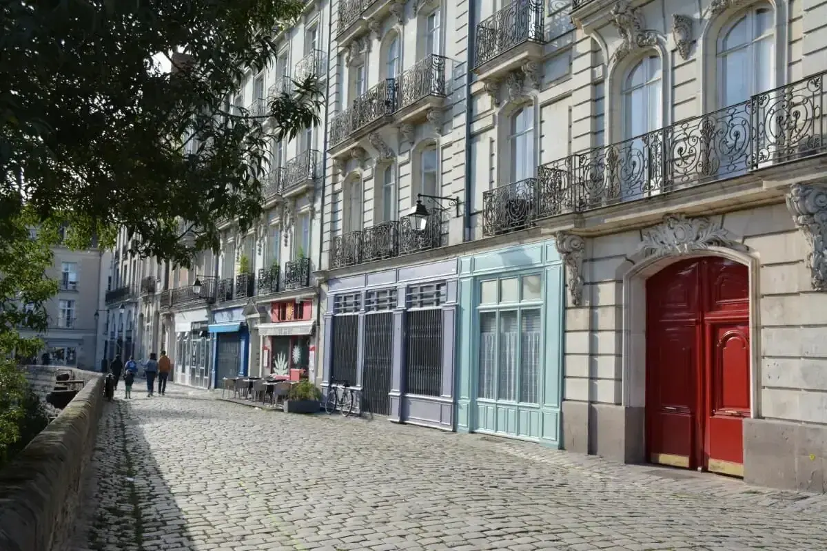 Rue pavée bordée d'immeubles anciens en centre-ville
